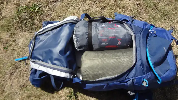 Here the tent and pad are side by side positioned vertically in the main compartment.
