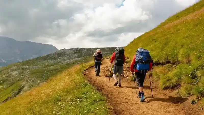 Are Canvas Backpacks Good for Hiking - top picture with three hikers walking up a path in the mountains.